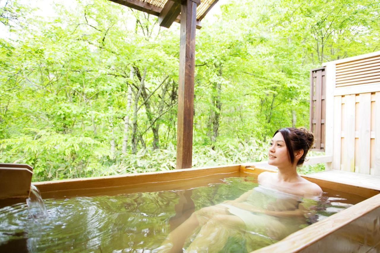 Miyama Ouan Kyoritsu Resort Takayama  Buitenkant foto A woman bathing in a hot spring